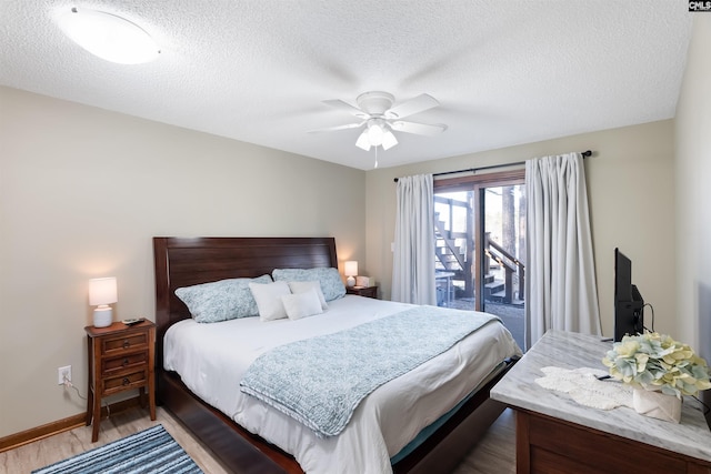 bedroom featuring ceiling fan, hardwood / wood-style floors, access to exterior, and a textured ceiling