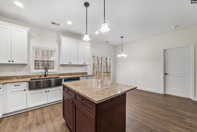 kitchen featuring sink, hanging light fixtures, a center island, white cabinets, and dark hardwood / wood-style flooring