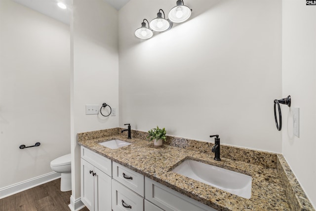 bathroom featuring vanity, hardwood / wood-style flooring, and toilet