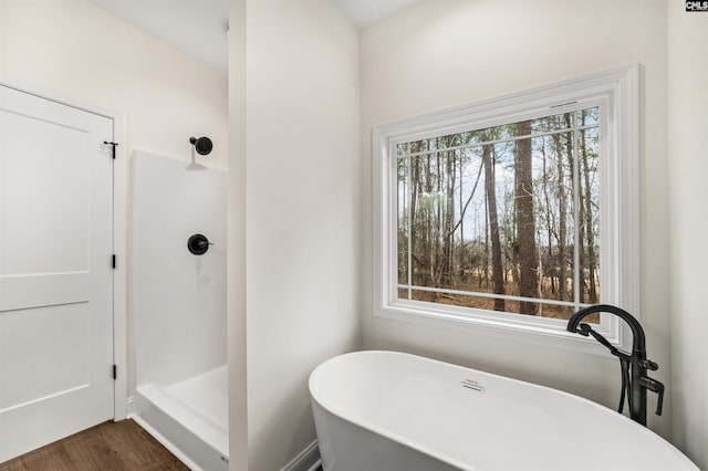 bathroom with independent shower and bath, plenty of natural light, and hardwood / wood-style floors