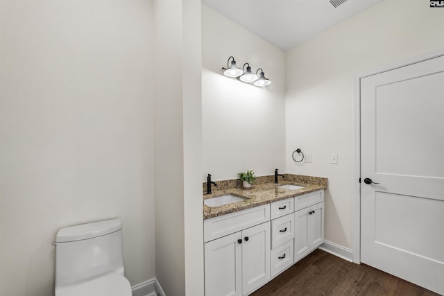 bathroom featuring vanity, wood-type flooring, and toilet