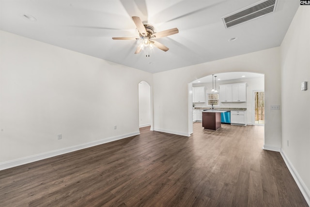 unfurnished living room with dark hardwood / wood-style floors and ceiling fan