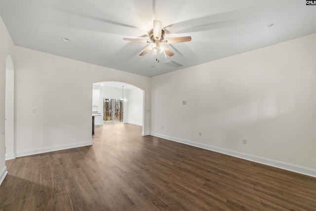 unfurnished room featuring ceiling fan with notable chandelier and dark hardwood / wood-style floors