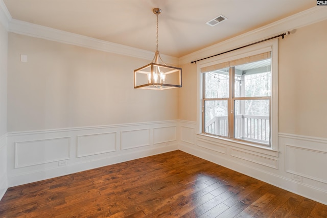 unfurnished room featuring an inviting chandelier, crown molding, and dark wood-type flooring