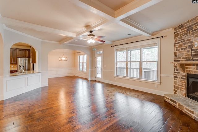 unfurnished living room featuring beamed ceiling, wood-type flooring, and a fireplace