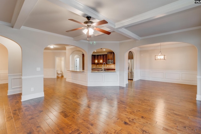 unfurnished living room with beam ceiling, wood-type flooring, and ceiling fan