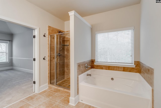 bathroom featuring tile patterned flooring and separate shower and tub