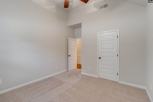 unfurnished bedroom featuring ceiling fan, high vaulted ceiling, and light carpet