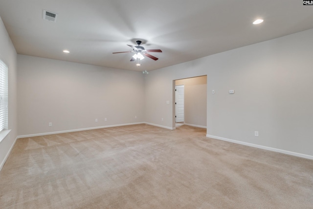 spare room with light colored carpet and ceiling fan