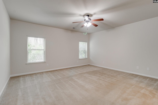 empty room featuring ceiling fan and light colored carpet