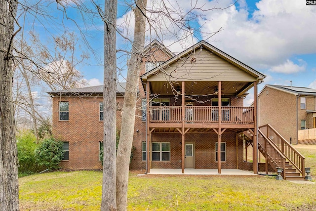 rear view of house with a patio, a wooden deck, a yard, and ceiling fan