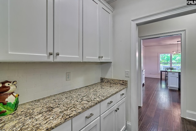 kitchen featuring decorative backsplash, dark hardwood / wood-style floors, white cabinets, and dark stone counters