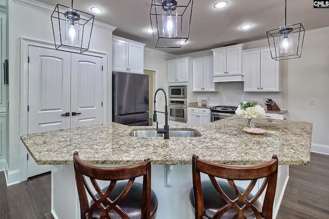 kitchen featuring pendant lighting, stainless steel appliances, and a large island with sink