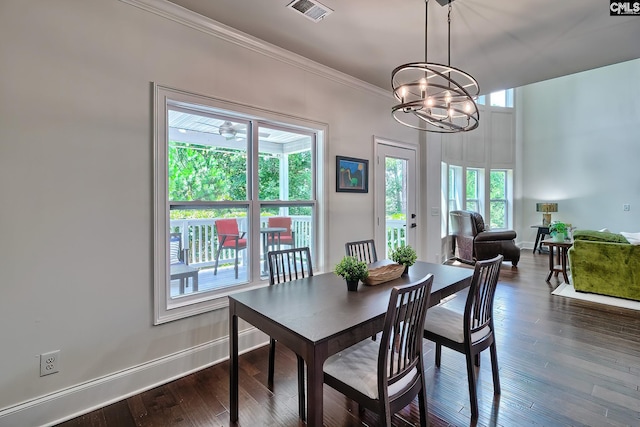 dining space with dark hardwood / wood-style flooring, a notable chandelier, and crown molding