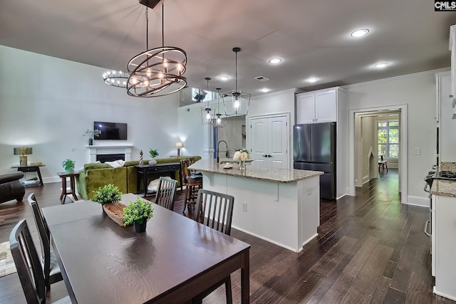 dining area featuring dark hardwood / wood-style flooring, sink, and ornamental molding