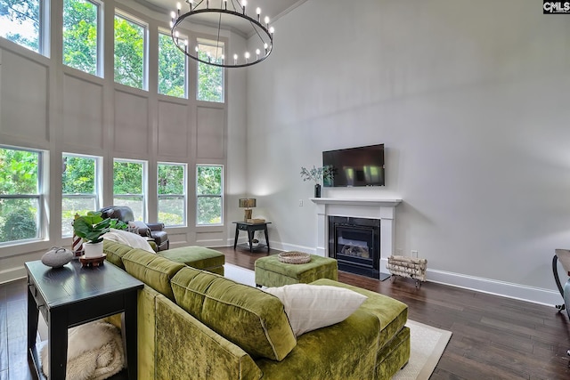 living room with a towering ceiling, dark hardwood / wood-style flooring, and a notable chandelier