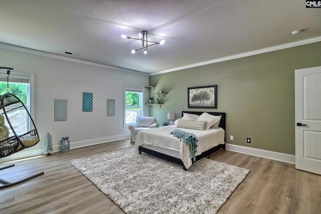 bedroom with ornamental molding, hardwood / wood-style floors, and a notable chandelier