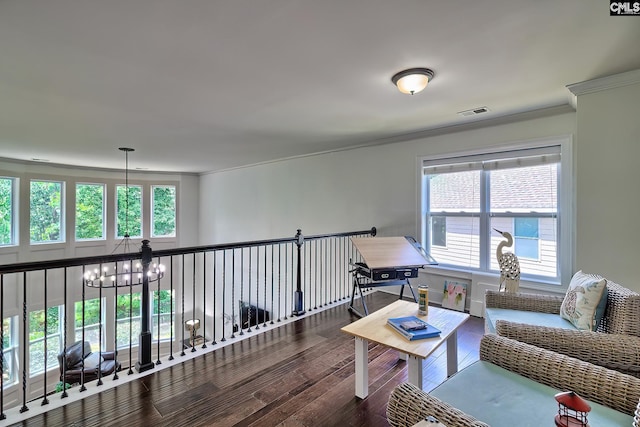 living area featuring wood-type flooring, a notable chandelier, and crown molding