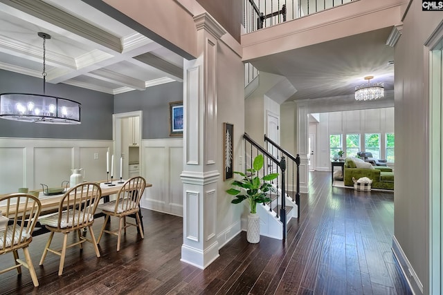 dining area with dark wood-type flooring, coffered ceiling, ornamental molding, a notable chandelier, and beam ceiling