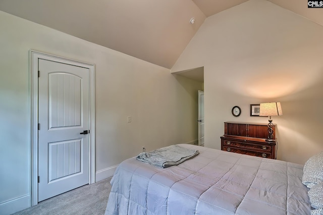 bedroom with vaulted ceiling and light carpet