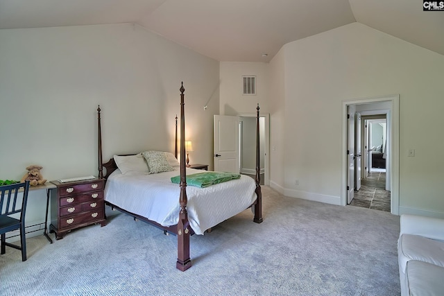 carpeted bedroom with high vaulted ceiling