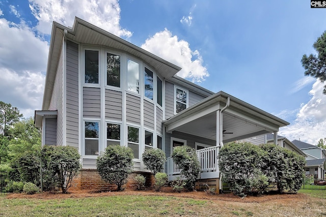 exterior space featuring ceiling fan, covered porch, and a lawn