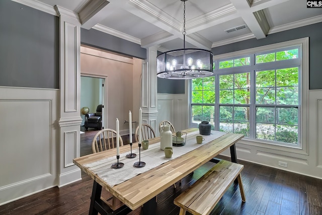 dining area featuring dark wood-type flooring, a chandelier, beamed ceiling, and ornate columns