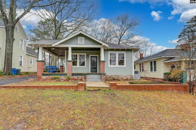 bungalow-style home featuring a front lawn and a porch