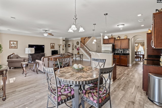 dining area with crown molding, ceiling fan, and light hardwood / wood-style flooring