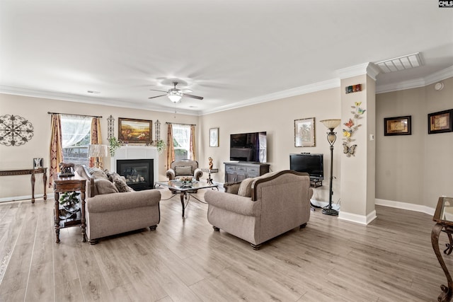 living room featuring crown molding, ceiling fan, and light wood-type flooring