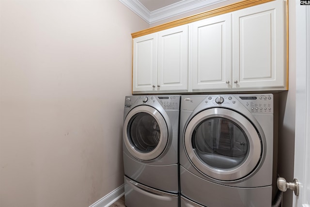 clothes washing area featuring independent washer and dryer, crown molding, and cabinets