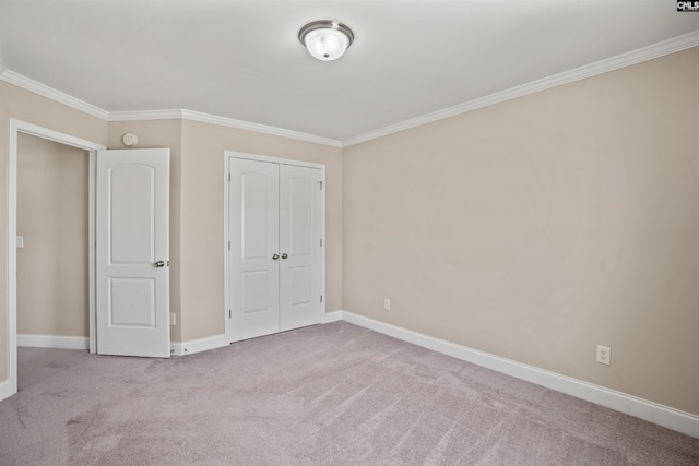 unfurnished bedroom featuring crown molding, light colored carpet, and a closet