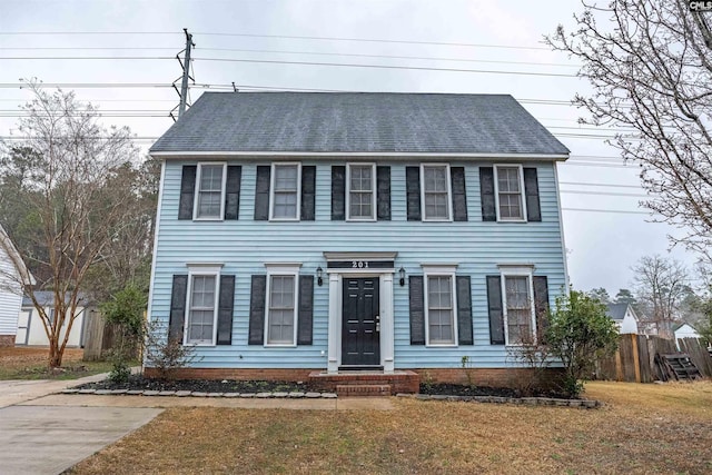 colonial-style house featuring a front yard