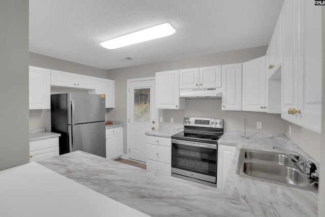 kitchen featuring stainless steel appliances, sink, white cabinets, and a textured ceiling