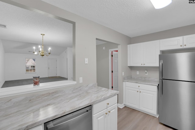 kitchen with light hardwood / wood-style flooring, white cabinetry, stainless steel appliances, a textured ceiling, and decorative light fixtures