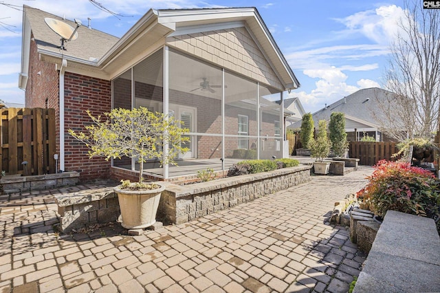 view of patio with ceiling fan, an outdoor fire pit, and a sunroom