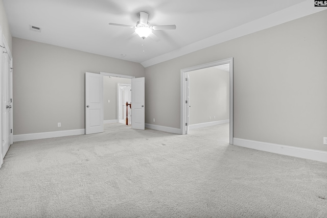 unfurnished bedroom featuring ceiling fan, vaulted ceiling, and light carpet