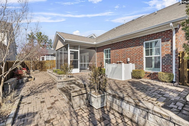 rear view of house featuring a patio and a sunroom