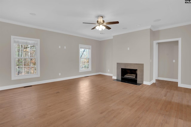 unfurnished living room featuring ceiling fan, ornamental molding, a fireplace, and light hardwood / wood-style flooring