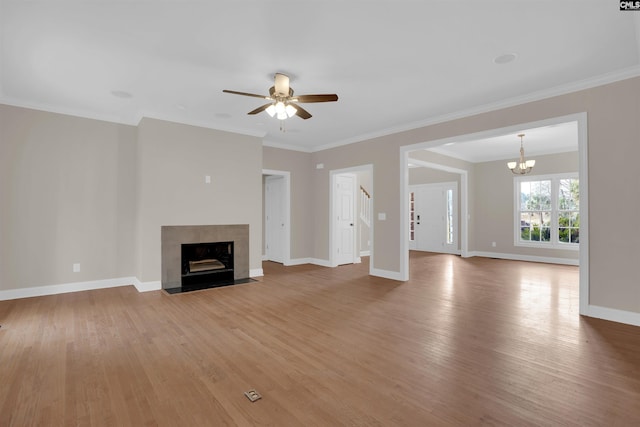 unfurnished living room with hardwood / wood-style floors, ceiling fan with notable chandelier, a fireplace, and ornamental molding