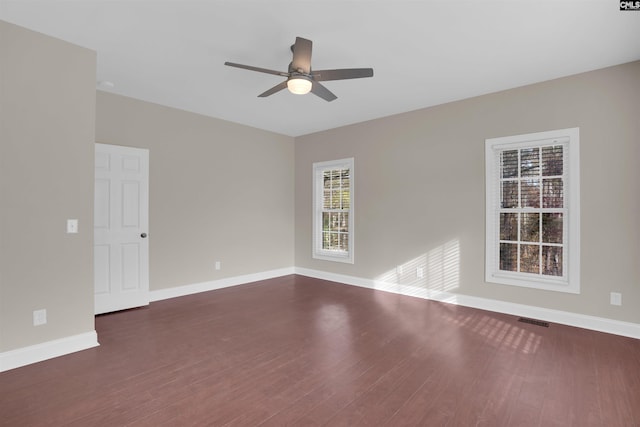 empty room featuring dark wood-type flooring and ceiling fan