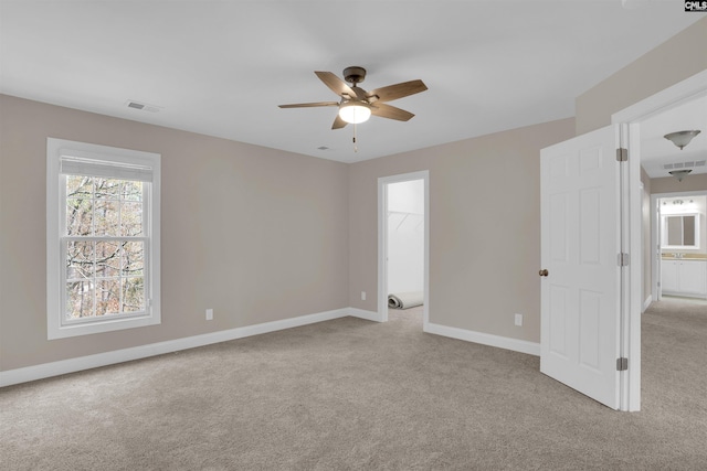 carpeted spare room featuring ceiling fan