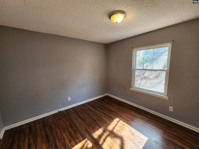 unfurnished room featuring dark hardwood / wood-style floors and a textured ceiling