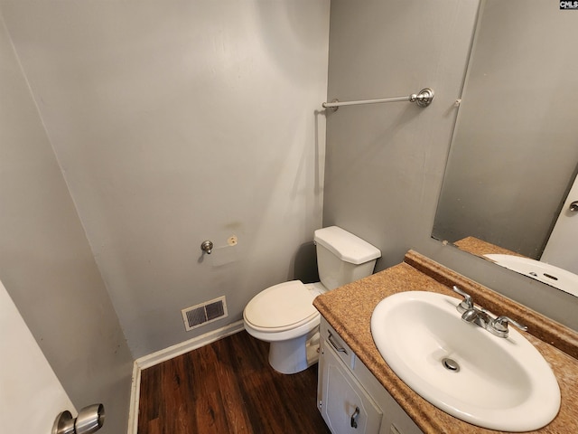 bathroom featuring vanity, wood-type flooring, and toilet