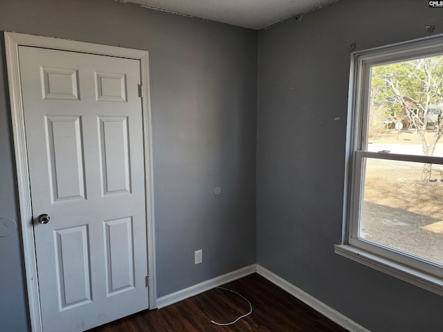 unfurnished room featuring dark wood-type flooring