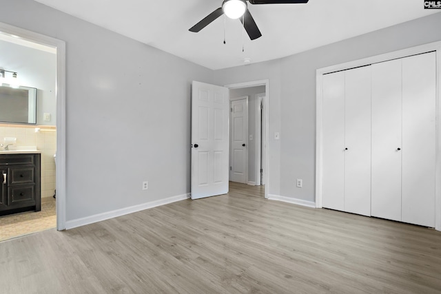 unfurnished bedroom with ceiling fan, a closet, ensuite bathroom, and light hardwood / wood-style flooring