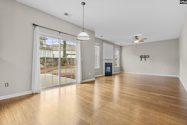 unfurnished living room featuring ceiling fan and light hardwood / wood-style flooring