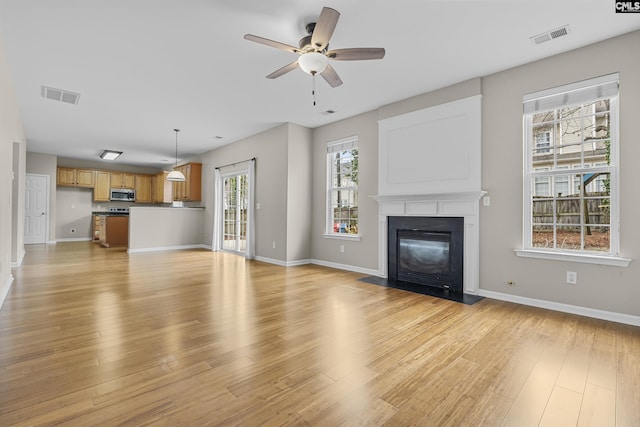 unfurnished living room with light hardwood / wood-style flooring and ceiling fan