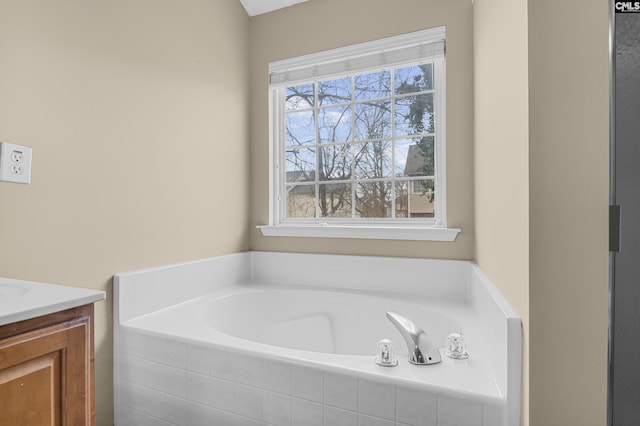 bathroom with vanity and tiled bath