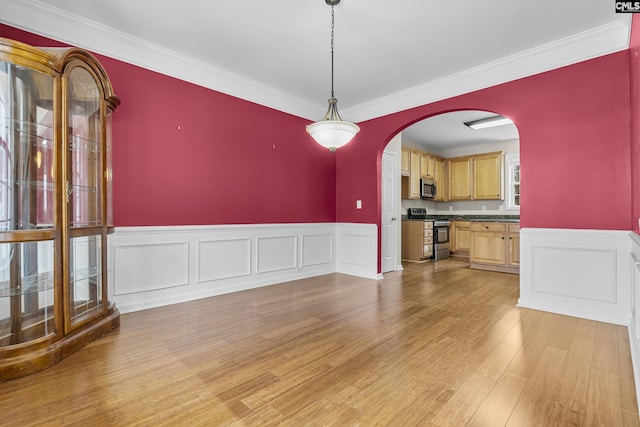 unfurnished dining area featuring ornamental molding and light hardwood / wood-style floors